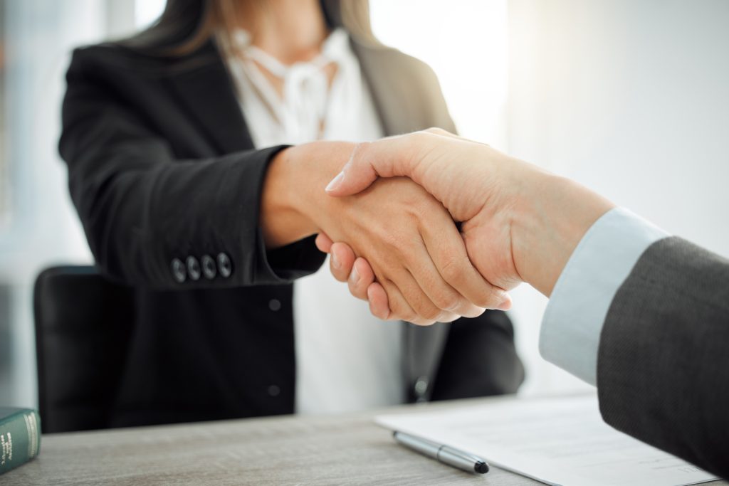 Shot of two lawyers shaking hands in greeting