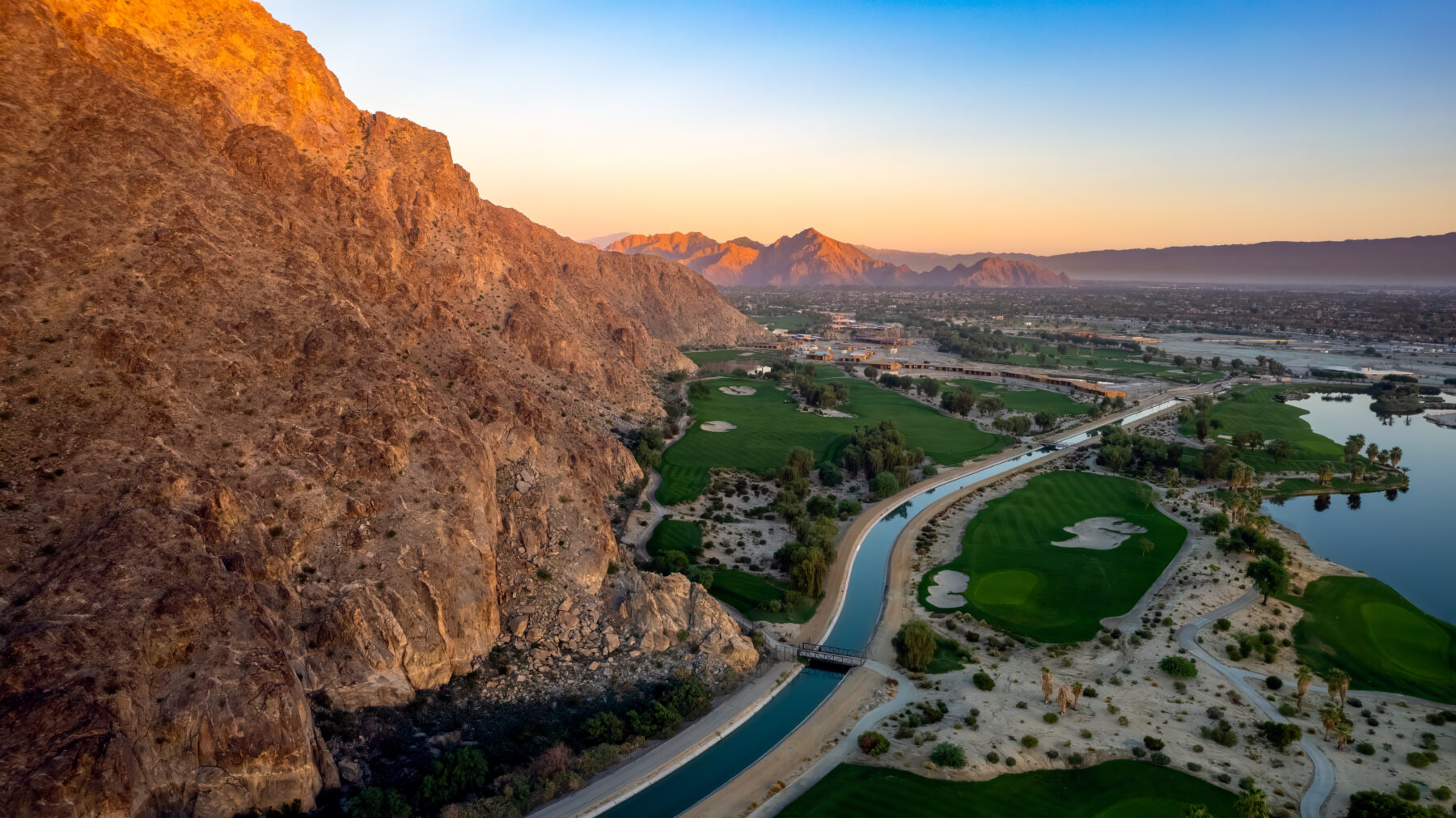 Dramatic aerial view at sunrise over the Coachella Canal and mountains in La Quinta. Mountains in the distance.